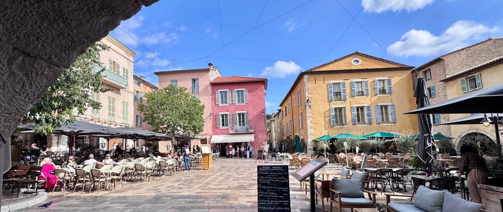 Place des Arcades in Valbonne, café tables, arcades, late-morning autumn light.
